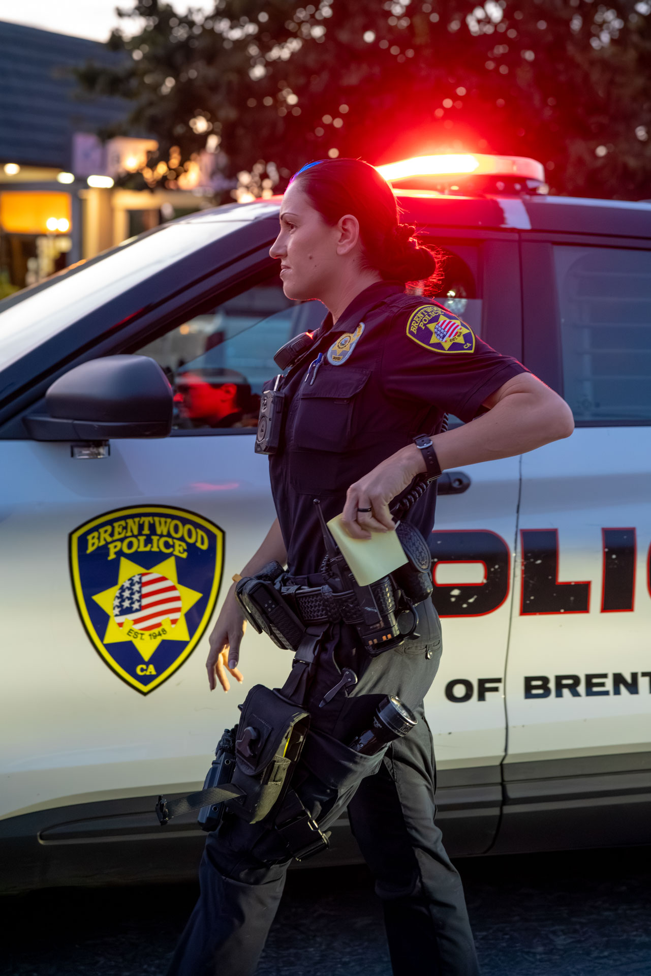 Brentwood officer walking past patrol vehicle at dusk